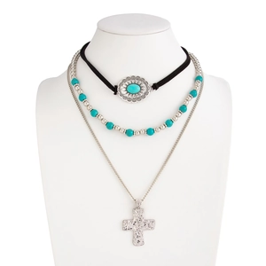 Detail of bohemian layered necklace with turquoise beads and silver cross pendant