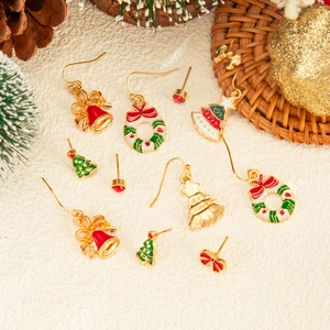 Detailed set of Christmas earrings featuring enamel snowflakes and reindeer on white texture