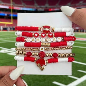 Close-up of seven elastic Game Day bracelets featuring red football charms and heishi beads