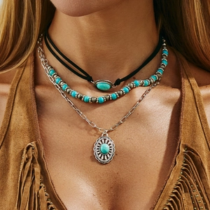 Detail of bohemian layered necklace with turquoise stones and tribal flower pendant