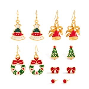 Close-up of Christmas earring set with enamel snowflakes and reindeer on white backdrop