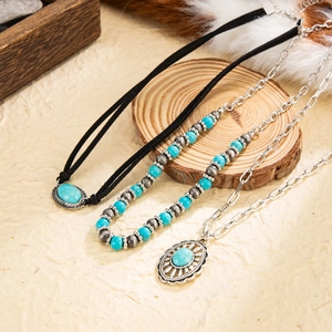 Bohemian necklaces with turquoise stones and vintage silver charms on a rustic background