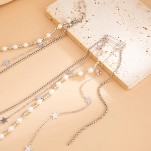 Détails d'une broche épingle à nourrice avec pendentifs étoiles et pompons en perles
