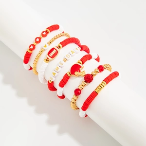 Macro shot of red and white acrylic beaded bracelets with metal charms for game day
