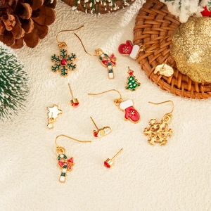 Christmas themed earring set with snowflake and reindeer charms on festive background
