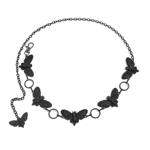 Détail de breloques papillon noires sur une chaîne de taille en métal punk