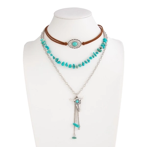 Detailed view of bohemian layered necklace with turquoise stones and silver bull skull pendant