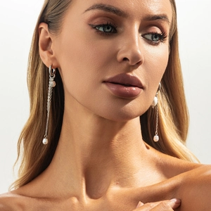 Gros plan de boucles d'oreilles à franges argentées et perles baroques sur un mannequin