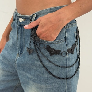 Détail de la chaîne de pantalon multicouche noire avec charmes papillon et tête de mort