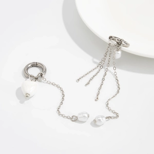 Détail de boucles d'oreilles chaînes argentées avec perles cœur et pompons multicouches