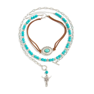 Close-up of layered necklace set featuring turquoise beads and bull head pendant