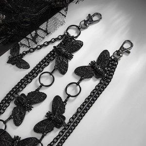 Macro shot of dark metal multi-layer waist chain with detailed moth charms and gothic lace