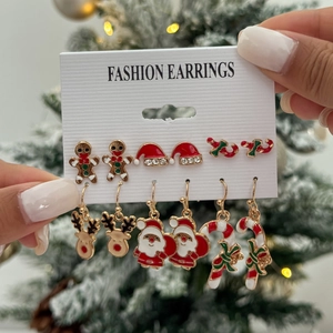 Close-up of 6 pairs of Christmas earrings featuring reindeer, Santa, and gingerbread motifs