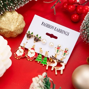 Detail view of 6-pair Christmas earring set with Santa, elk and tree motifs on red background