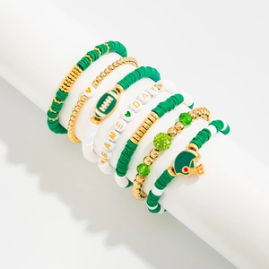 Macro view of Game Day beaded bracelets set with football charms and acrylic letters