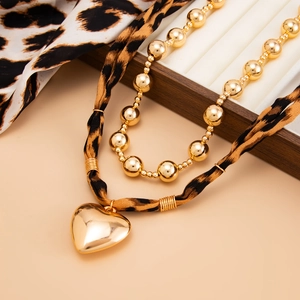 Exaggerated metal heart pendant necklace with leopard print scarf and gold bead chain