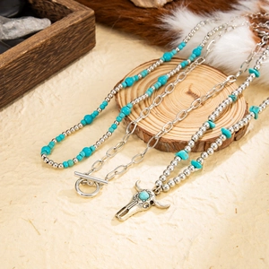 Bohemian silver necklaces featuring turquoise beads and a detailed bull skull pendant