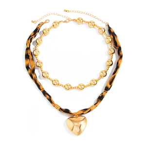 Double-layer necklace featuring leopard print cord, gold beads, and a large heart pendant