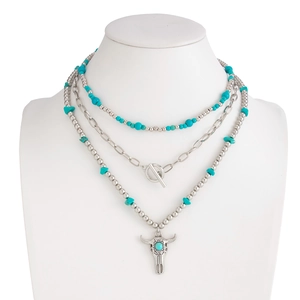 Detail view of ethnic layered necklace featuring turquoise beads and a bull head pendant