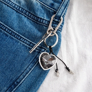 Irregular heart shaped crystal keychain with pendants on blue denim jeans pocket