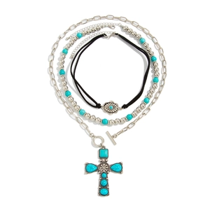Three-layer bohemian necklace featuring a cross pendant with turquoise stones and toggle clasp