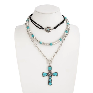 Close-up of bohemian layered necklace set with turquoise beads and large cross pendant