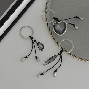 Industrial style keychain with dark faceted acrylic heart and geometric pendants on metal ring