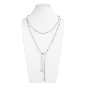 Detail van een zilveren kralen Y-ketting met dubbele lagen en twee glanzende hangers