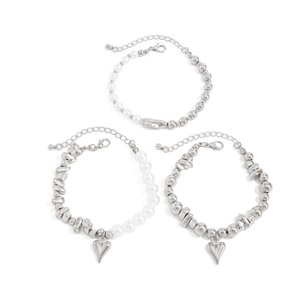 Detailaufnahme eines 3-teiligen silbernen Armband-Sets mit Herzanhängern und Perlen