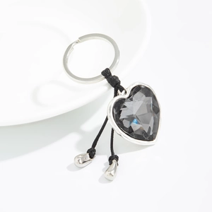 Macro shot of heart-shaped dark grey faceted crystal keychain with silver metallic frame