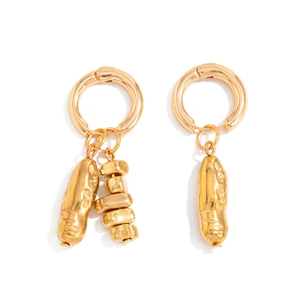 Détail de boucles d'oreilles asymétriques en métal doré avec pendentifs irréguliers