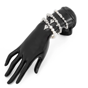 Makro-Detail des mehrlagigen Armbands mit Herzanhänger und Perlen auf Handmodell