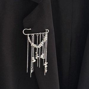 Broche à pampilles argentée avec perles en métal sur revers de veste noire chic