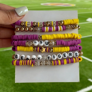 Close-up of LSU and Geaux Tigers beaded bracelets with clay discs and gold stars