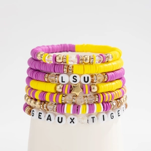 Detail of purple and yellow LSU themed beaded bracelets with GEAUX TIGERS letter charms