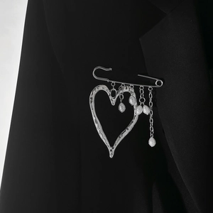 Detail of silver heart brooch with pearl tassels pinned on a premium black suit blazer