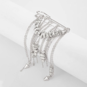 Dettaglio della spilla da balia in metallo argento con catene pendenti e perline decorative