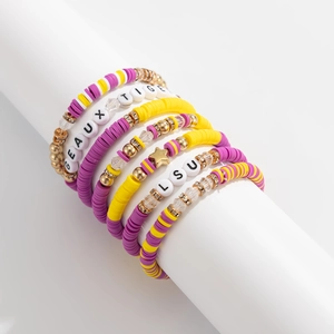 Detail view of LSU themed purple and gold beaded bracelets with GEAUX TIGERS letter charms