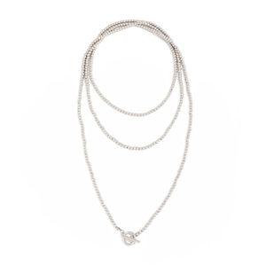 Detail van zilveren gelaagde kralenketting met een stijlvolle metalen toggle sluiting