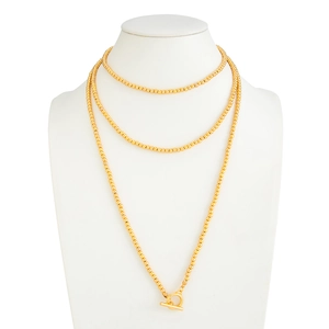 Detail van een lange gouden kralenketting met een minimalistische metalen OT-sluiting