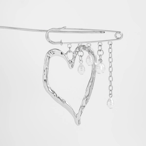 Detailed view of silver heart pendant brooch with pearl tassels and hammered texture