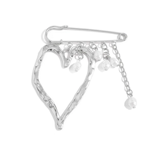 Detail of silver safety pin brooch with lava heart pendant and white pearl tassels