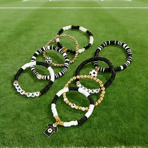 Detailed macro view of soccer-themed beaded bracelets on green grass background