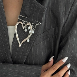 French lava heart brooch pin with white pearl tassels on a striped suit lapel