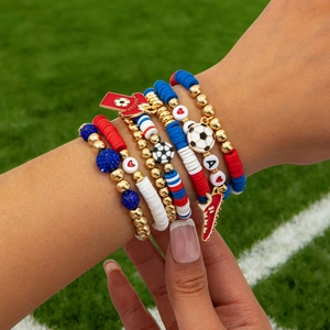 Detail of red white and blue soccer themed heishi bead bracelet set with charms