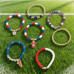 Detail of 7-piece Super Bowl themed acrylic and clay bead bracelets on green soccer grass