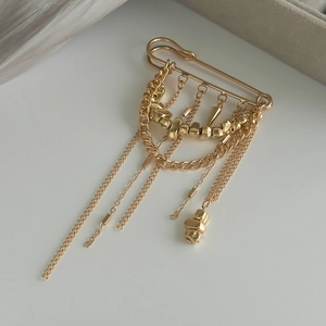 Détail de la broche à franges dorées avec perles métalliques CCB irrégulières