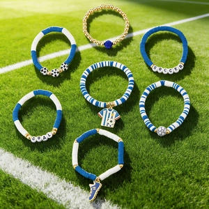 Close-up of soccer themed beaded bracelets with jerseys on green grass field