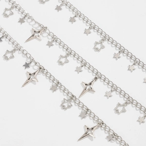 Detail of silver layering chains with diverse star pendants and hip-hop tassels