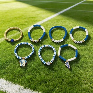 Detail of soccer themed beaded bracelet set with charms on green grass background